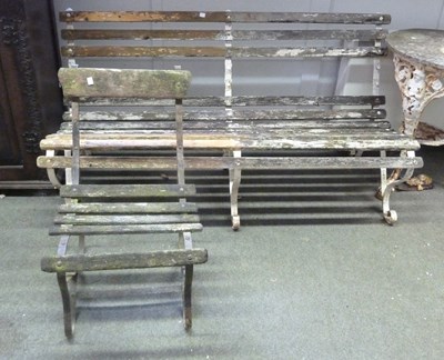 Lot 15 - A slatted garden seat with wrought iron scroll...