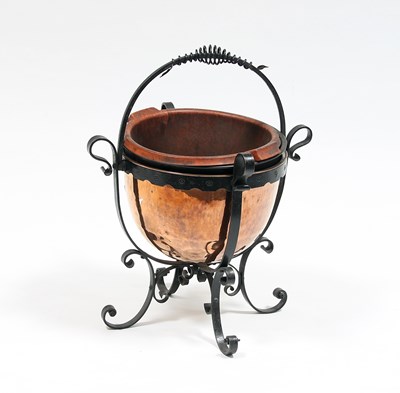 Lot 119 - A wrought iron framed log basket with swing...