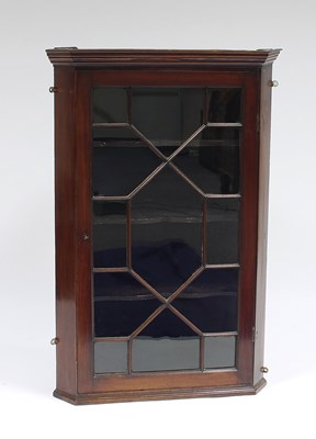 Lot 147 - An early 19th Century mahogany corner cupboard...