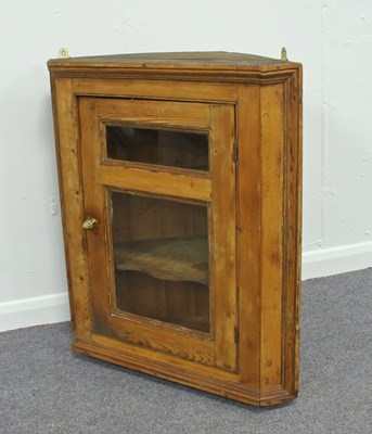 Lot 203 - A pine corner cupboard enclosed by a glazed...