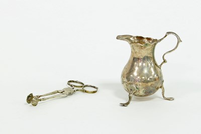 Lot 494 - A small silver bellied cream jug with double...