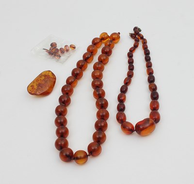 Lot 558 - Two amber bead necklaces, both translucent...