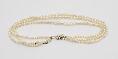 Lot 581 - A three-row cultured pearl necklace of...