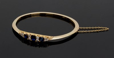 Lot 596 - A sapphire and diamond hinged bangle, the...