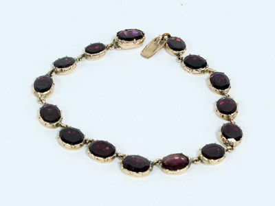 Lot 603 - A gold and garnet bracelet, graduated with...