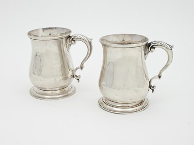 Lot 1106 - A pair of George II silver baluster mugs,...