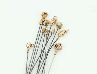 Lot 1218 - A collection of gold hat pins, three decorated...