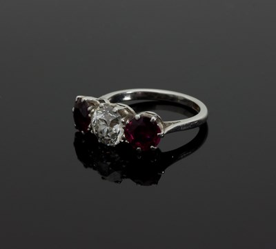 Lot 1285 - A three-stone ruby and diamond ring, claw set...