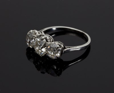 Lot 1287 - A three-stone diamond ring, claw set with old...