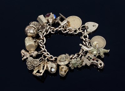 Lot 1291 - A 9ct gold charm bracelet with heart shaped...