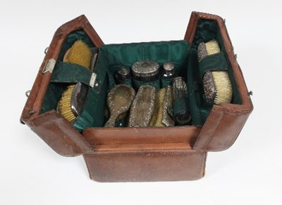 Lot 235 - A leather dressing case containing silver...