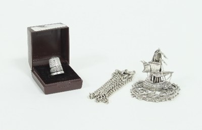 Lot 333 - A silver thimble, a menu holder in the form of...