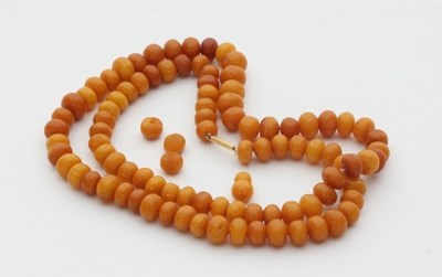 Lot 442 - An amber bead necklace, the beads of irregular...