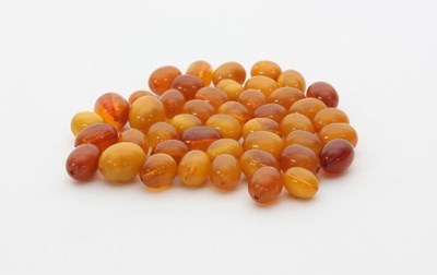 Lot 443 - A quantity of loose amber beads, of oval shape,...