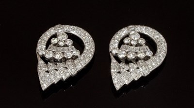 Lot 471 - A pair of diamond set clips of stylised scroll...