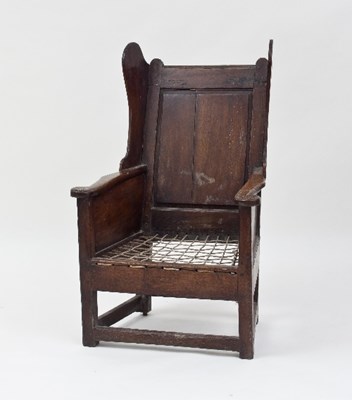 Lot 582 - An 18th Century oak lambing chair with wing...