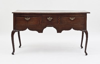 Lot 616 - An oak three-drawer dresser with shaped apron,...