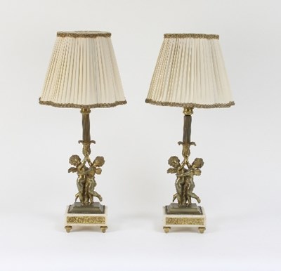 Lot 675 - A pair of gilt metal cherub table lamps on...