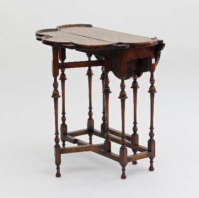 Lot 683 - A walnut drop-leaf gateleg table, with lobed...