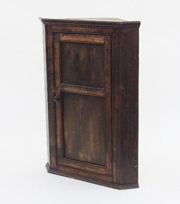 Lot 772 - An oak corner cupboard enclosed by a door,...