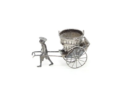 Lot 6 - A Chinese white metal figure of a man pulling...