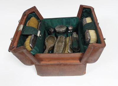 Lot 16 - A leather dressing case containing silver...