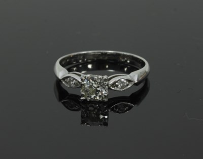 Lot 55 - A diamond ring, the central claw set stone...