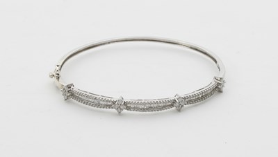 Lot 63 - A diamond set hinged bangle, set with three...