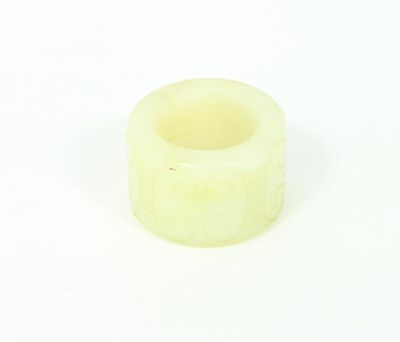 Lot 236 - A celadon jade ring carved with scrollwork,...