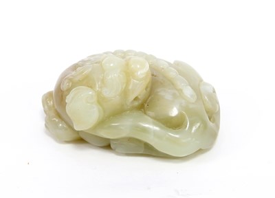 Lot 237 - A celadon jade carving of a sleeping lion,...