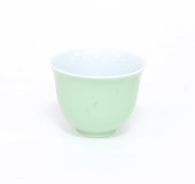 Lot 243 - A Chinese celadon glazed cup with flared rim,...