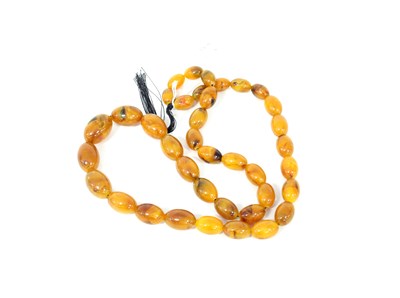 Lot 299 - An amber bead necklace of 38 beads, 80cm long,...