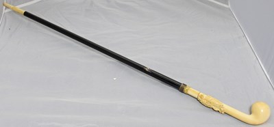 Lot 494 - An ivory and ebony walking cane with ivory...