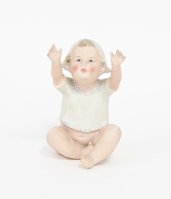 Lot 546 - A bisque piano doll of a baby reaching upwards,...