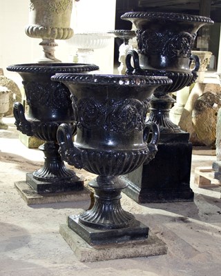 Lot 657 - Three cast iron campana shaped two-handled...