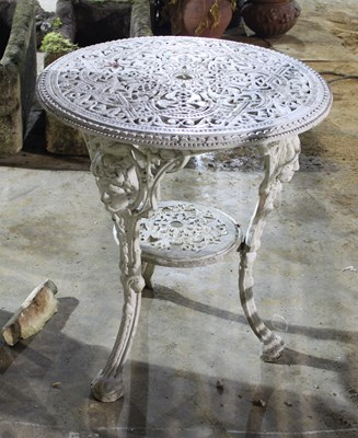 Lot 675 - An iron garden table on three legs with mask...