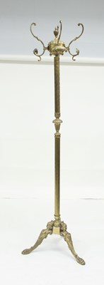 Lot 710 - A brass coat and hat stand on a tripod base,...