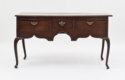 Lot 766 - An oak three-drawer dresser with shaped apron,...