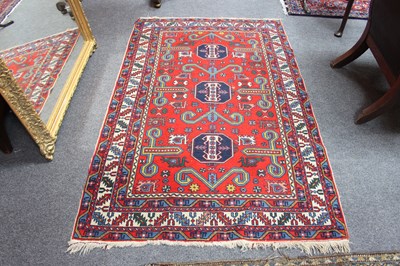 Lot 908 - An Afghan rug with red ground central field,...