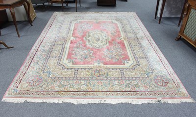 Lot 5 - A Persian wool carpet, the central pink field...