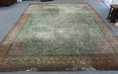 Lot 15 - A large Persian rug worked with forest scenes...