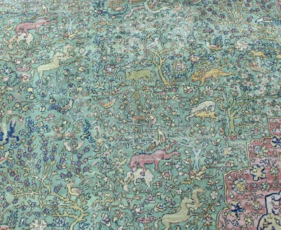 Lot 15 - A large Persian rug worked with forest scenes...