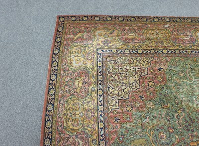 Lot 15 - A large Persian rug worked with forest scenes...