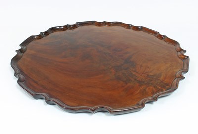 Lot 91 - A circular mahogany tray with piecrust border,...