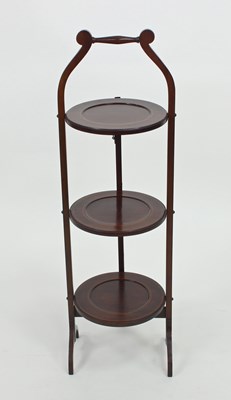 Lot 129 - A three-tier mahogany cake stand on splay feet