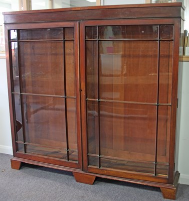 Lot 187 - A mahogany bookcase enclosed by twin glazed...