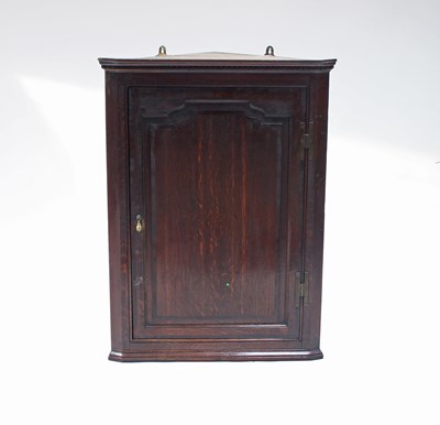 Lot 196 - A George III oak corner cupboard, with dentil...