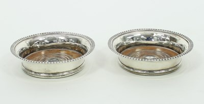 Lot 609 - A pair of George III silver decanter coasters,...