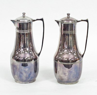 Lot 677 - A pair of plated Thermos jugs with hinged...