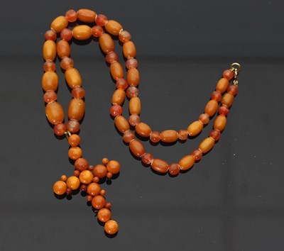 Lot 705 - An amber cross, the circular beads of...